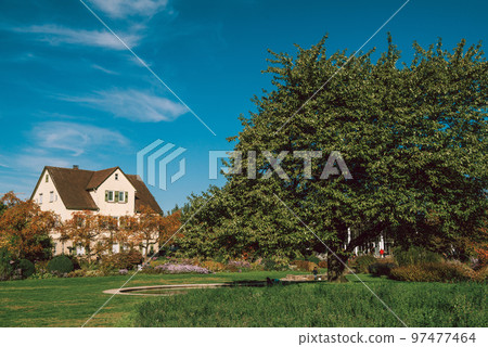 House with nice garden in fall. Flowers in the City Park of Bietigheim-Bissingen, Baden-Wuerttemberg, Germany, Europe. Autumn Park and house, nobody, bush and grenery House with nice garden in fall. Flowers in the City Park of Bietigheim-Bissingen, Baden-Wuerttemberg, Germany, Europe. Autumn Park and house, nobody, bush and grenery 97477464