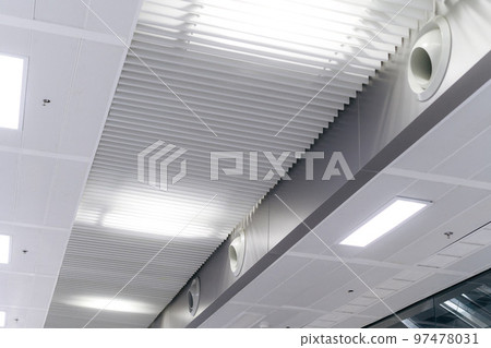 Ceiling mounted cassette type air conditioner and modern lamp light on white ceiling. duct air conditioner for home or office Ceiling mounted cassette type air conditioner and modern lamp light on white ceiling. duct air conditioner for home or office 97478031