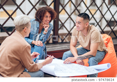 Architectural team engaged in discussing a technical drawing 97478614