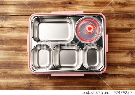 Metal lunch box with compartments on wooden background Metal lunch box with compartments on wooden background 97479239