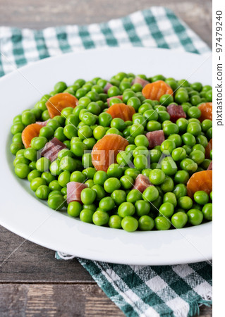 Green peas with serrano ham and carrot on wooden table Green peas with serrano ham and carrot on wooden table 97479240