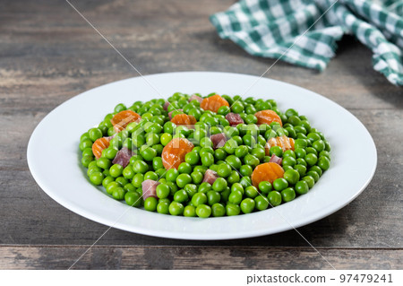 Green peas with serrano ham and carrot on wooden table Green peas with serrano ham and carrot on wooden table 97479241
