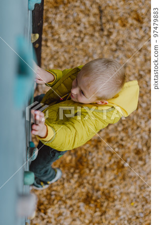 Boy At The Climbing Wall Without A Helmet, Danger At The Climbing Wall. Little Boy Climbing A Rock Wall Indoor Boy At The Climbing Wall Without A Helmet, Danger At The Climbing Wall. Little Boy Climbing A Rock Wall Indoor 97479883