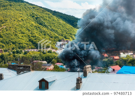 Fire. Close up of clouds of black smoke over a burning building. The concept of an emergency, disaster and insurance accident Fire. Close up of clouds of black smoke over a burning building. The concept of an emergency, disaster and insurance accident 97480713