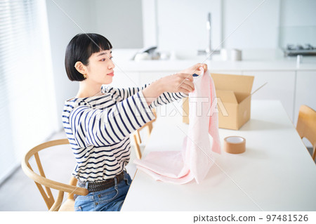 young woman holding clothes young woman holding clothes 97481526