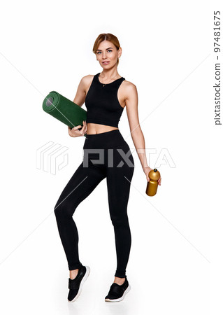 woman in sportswear holding yoga mat and bottle of water 97481675
