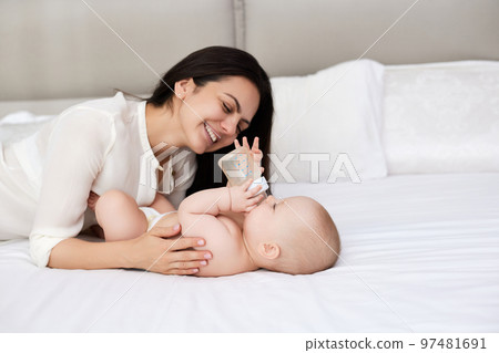 happy mother feeding her newborn baby on the bed 97481691
