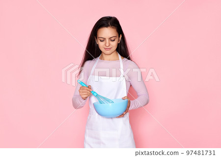 woman holding whisk and bowl with eggs 97481731