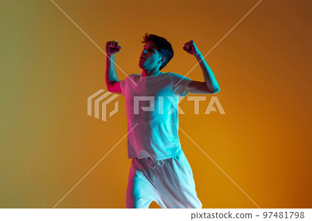 man dancing on yellow background. Neon lighting 97481798