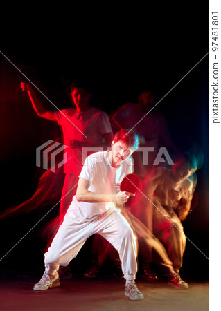 young man playing table tennis in mixed neon light 97481801