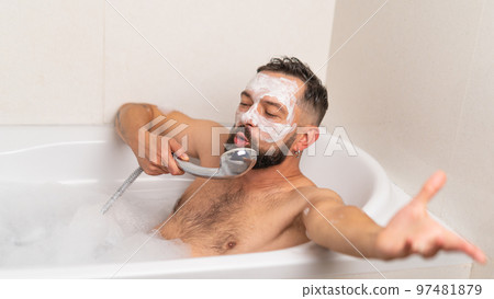 man with face mask relaxing in bath at home 97481879