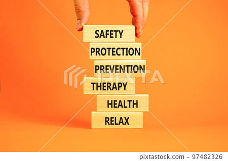 Health and safety symbol. Concept words Safety Protection Prevention Therapy Health Relax on wooden blocks on a beautiful orange table orange background. Businessman hand. Health and safety concept. Health and safety symbol. Concept words Safety Protection Prevention Therapy Health Relax on wooden blocks on a beautiful orange table orange background. Businessman hand. Health and safety concept. 97482326