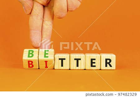 Better or bitter symbol. Concept word Better and Bitter on wooden cubes. Businessman hand. Beautiful orange table orange background. Business and better or bitter concept. Copy space. 97482329