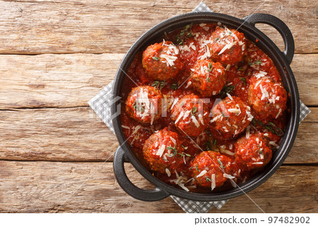 Polpette meatballs with parmesan stewed in a rich tomato sauce close-up in a frying pan. Horizontal top view 97482902