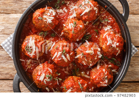 Italian Traditional Dish Polpette al sugo meatballs in tomato sauce on pan on wooden table. Horizontal top view 97482903