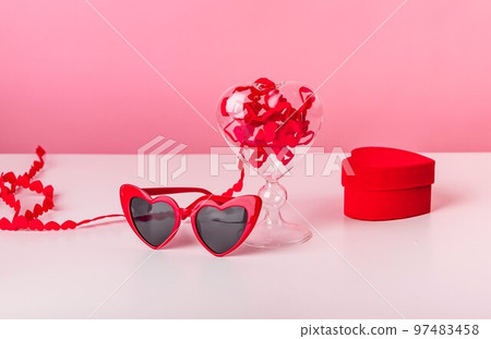 Valentines day concept. Hearts ribbon and red shaped glasses, box with engagement rings 97483458