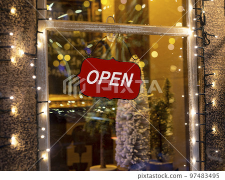 Open, text on signboard, sign board on shop, store window on winter holidays with Christmas decorations Open, text on signboard, sign board on shop, store window on winter holidays with Christmas decorations 97483495