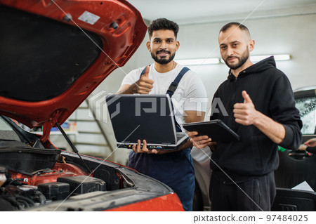 Serious focused men car technician mechanics repairing car problem of engine Serious focused men car technician mechanics repairing car problem of engine 97484025
