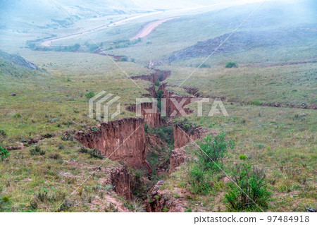 a large crack in the ground after seismic activity 97484918