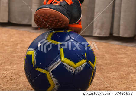 The ball and the foot in the boot are on top. 97485658