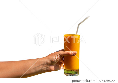 Girl holds in her hand a glass of freshly squeezed juice on a isolated background 97486022