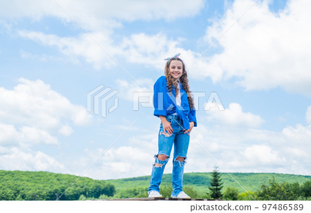 Funky beauty. happy childhood. cheerful teen girl has long curly hair. kid smiling outdoor. kid fashion and beauty. sense of freedom. portrait of pretty child girl. concept of future Funky beauty. happy childhood. cheerful teen girl has long curly hair. kid smiling outdoor. kid fashion and beauty. sense of freedom. portrait of pretty child girl. concept of future 97486589