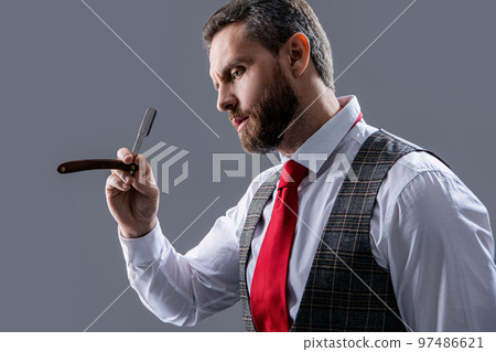 bearded man at barbershop. unshaven man hold blade in barbershop isolated on grey background. bearded man at barbershop. unshaven man hold blade in barbershop isolated on grey background. 97486621