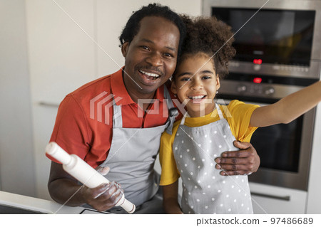 Cute Black Girl Taking Selfie With Her Dad While Cooking In Kitchen 97486689