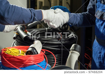 Electricians shake hands after successful work with plugs Electricians shake hands after successful work with plugs 97488204