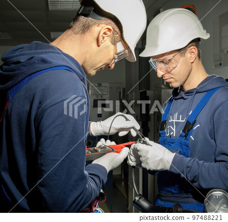 Electricians work in equipped laboratory with charging plug Electricians work in equipped laboratory with charging plug 97488221