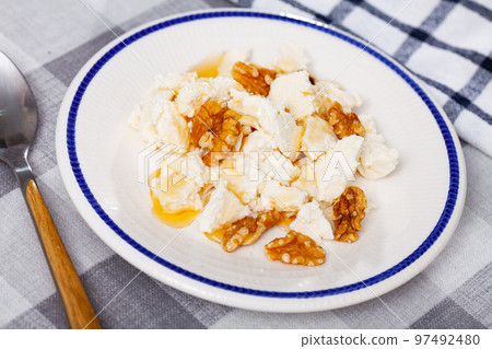 Fresh cottage cheese with honey and walnuts 97492480