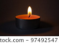 Candle on dark luxury night background. Black table, side view. Candles Burning at Night. Orange taper burning in focus, foreground. illustration design. 97492547