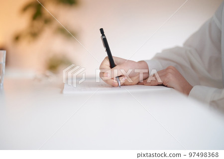 年輕女子在房間裡的筆記本上寫字 97498368