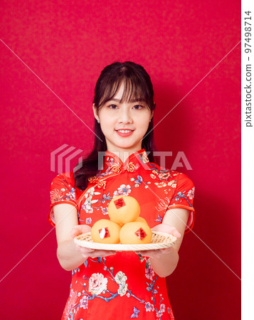 Young asian woman in traditional cheongsam man with small chinese festival couplet meaning good luck on red background 97498714
