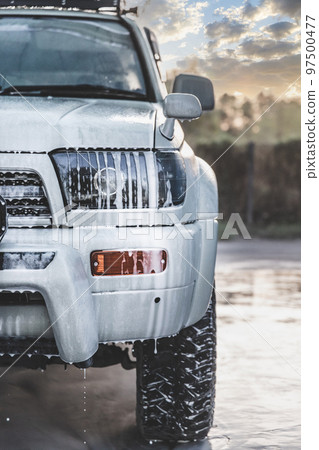 Large white SUV car in foam at a self-service car wash, vertical 97500477