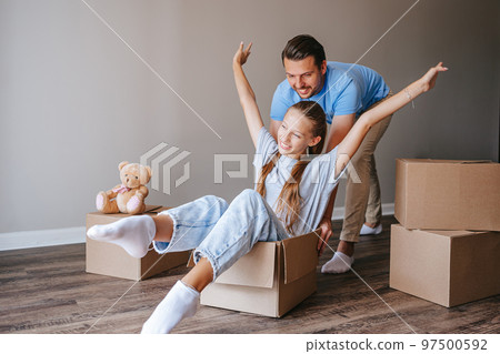 Family of father and adorable teen daughter have fun on moving day in their new home 97500592