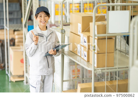 A worker scanning inventory with a handy terminal A worker scanning inventory with a handy terminal 97500862