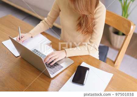 Business at home concept, Young Asian woman is reading data on laptop and taking notes on notebook Business at home concept, Young Asian woman is reading data on laptop and taking notes on notebook 97501038