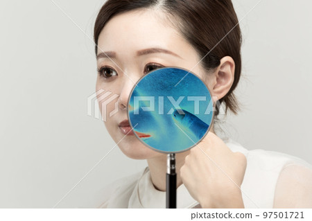 用放大鏡放大女人的皮膚，發現她皮膚上的斑點。 97501721