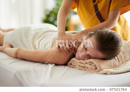 Middle-aged woman getting massage with oils in beauty salon 97501764