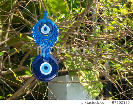 Close up of evil eye charms hang from a tree. Close up of evil eye charms hang from a tree. 97502553
