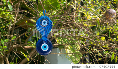 Close up of evil eye charms hang from a tree. Close up of evil eye charms hang from a tree. 97502554