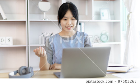 Young Asian women are greeting friends and teachers through video chats and greeting them with cheerful expressions, Online communication , Stay home, New normal, VDO Call, Social distancing 97503263