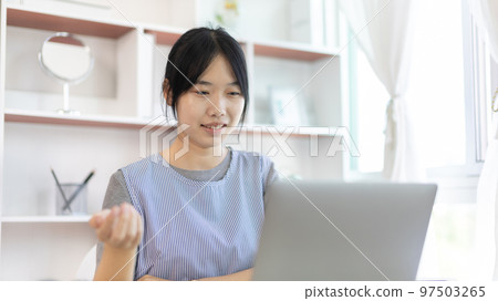 Young Asian women are greeting friends and teachers through video chats and greeting them with cheerful expressions, Online communication , Stay home, New normal, VDO Call, Social distancing 97503265