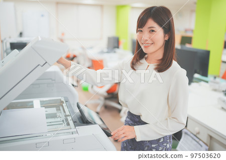 Woman operating a copier at work Woman operating a copier at work 97503620