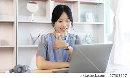 Young Asian women are greeting friends and teachers through video chats and greeting them with cheerful expressions, Online communication , Stay home, New normal, VDO Call, Social distancing 97505337