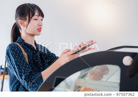 A young woman posting a review of a shop A young woman posting a review of a shop 97507362