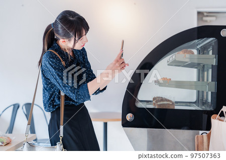 A young woman posting a review of a shop A young woman posting a review of a shop 97507363