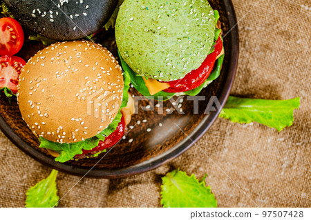 Top down view of set of three mini color homemade burgers with marble beef on rustic table 97507428