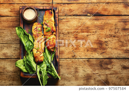 Chicken breast fried on skewers. 97507584